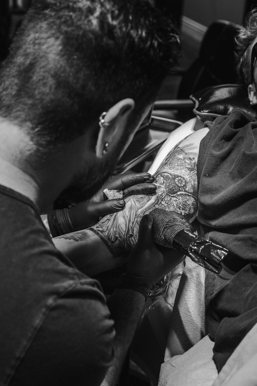 Black and grey tattoo detail — close-up of Jesse Vickers hands creating fine art tattoo